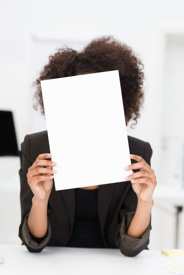 Businesswoman hiding behind a blank sheet of paper